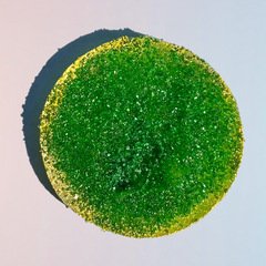 Round green apple sour crystal candy with bright green sugar crystals and a gold edge